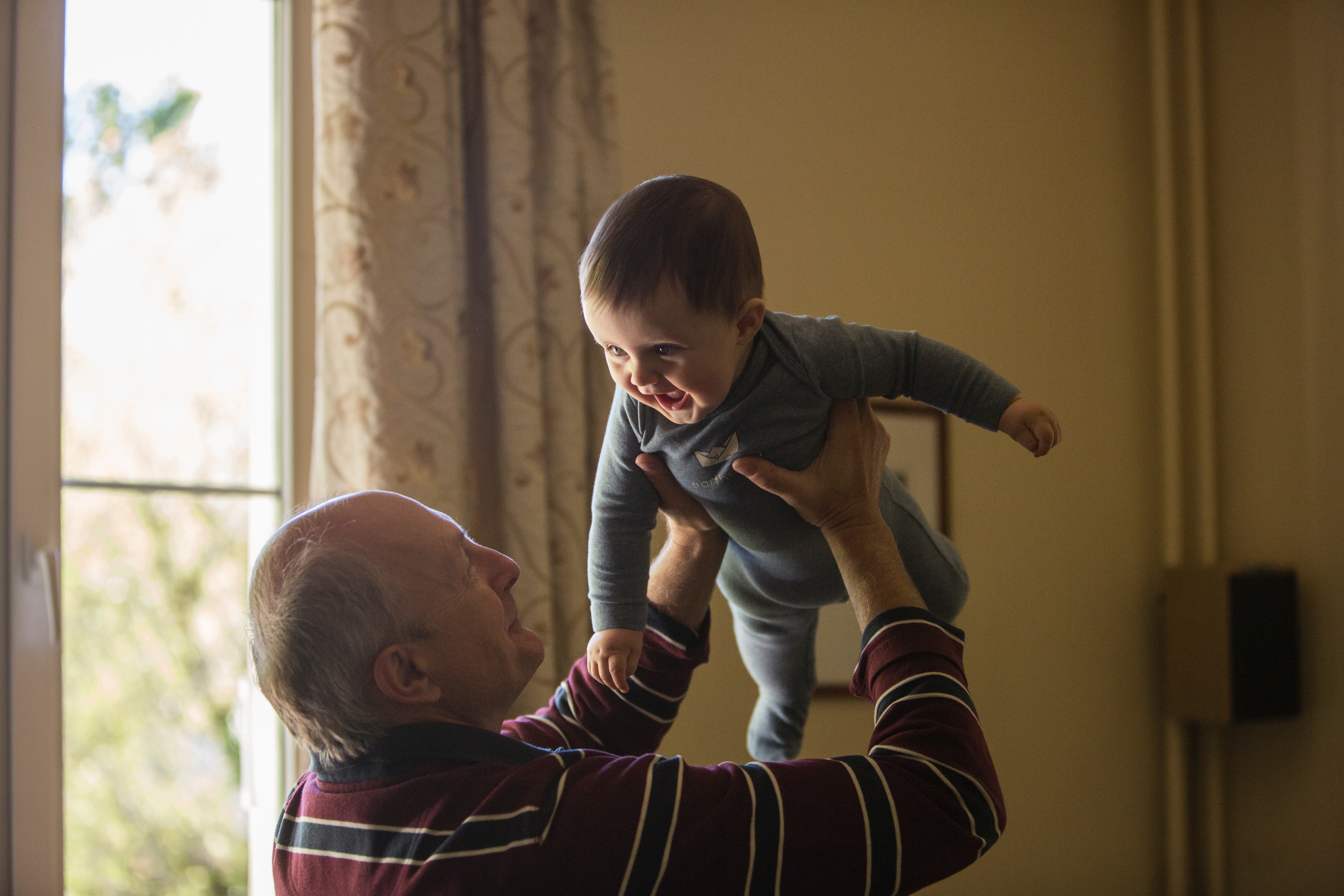 grandfather holding grandson smiling