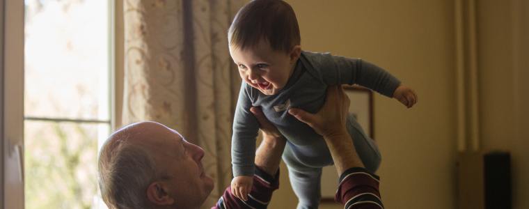 grandfather holding grandson smiling