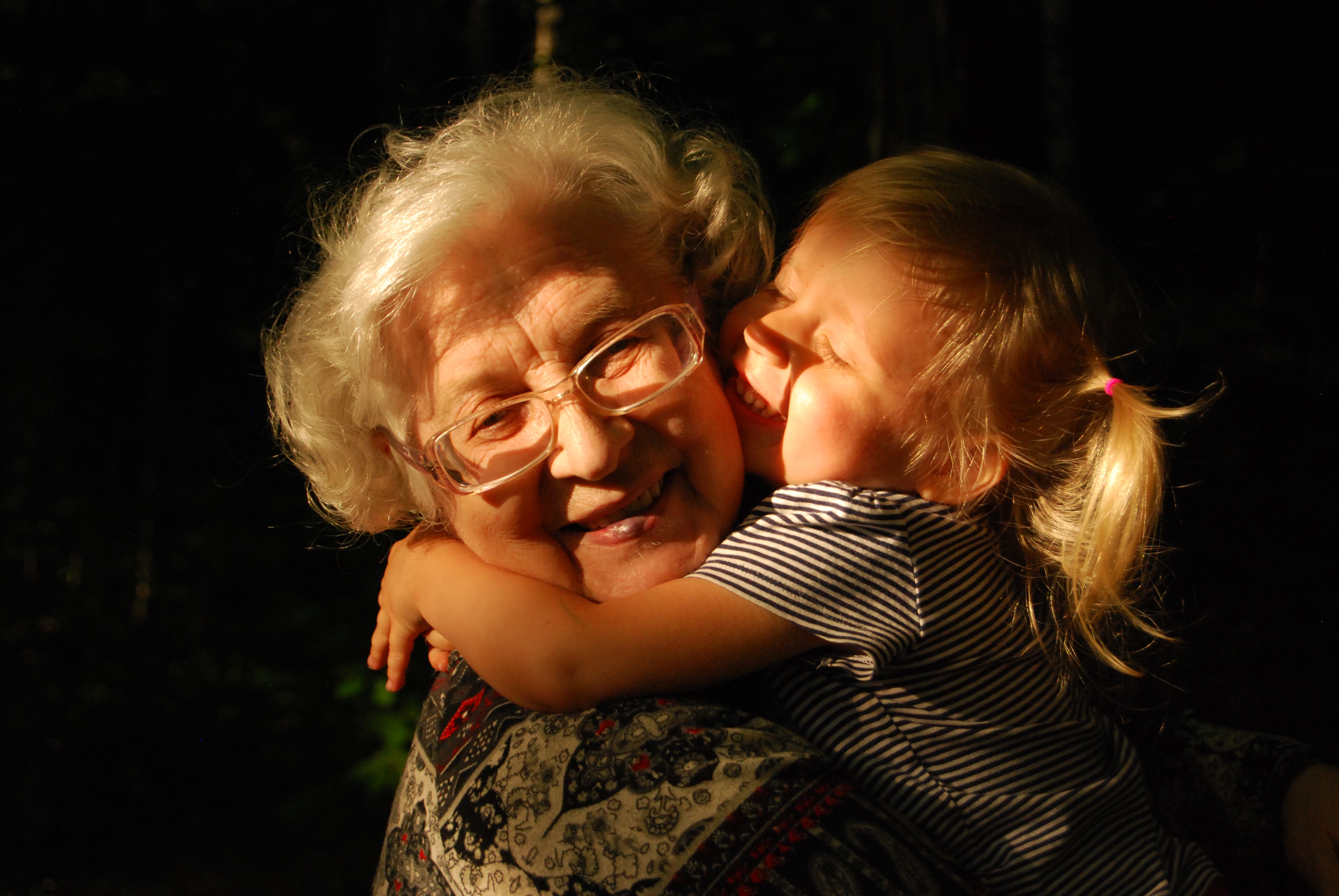 granddaughter hugging grandmother smiling