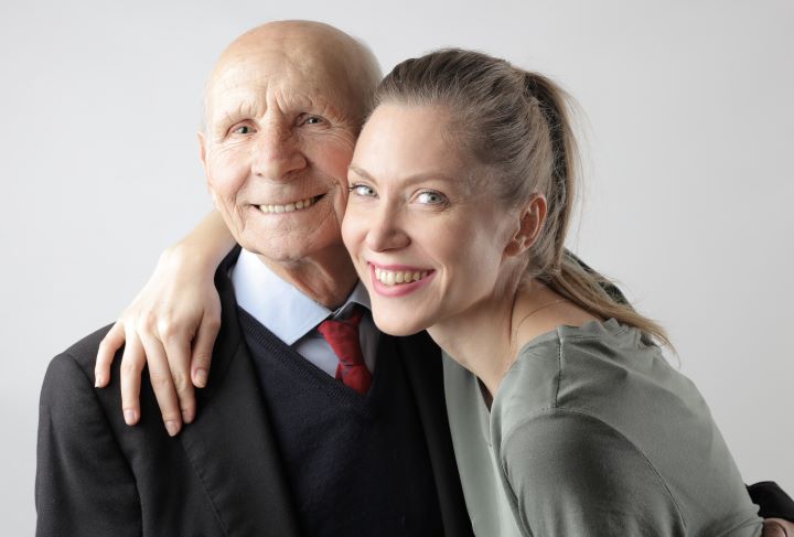 adult daughter with arm around senior father