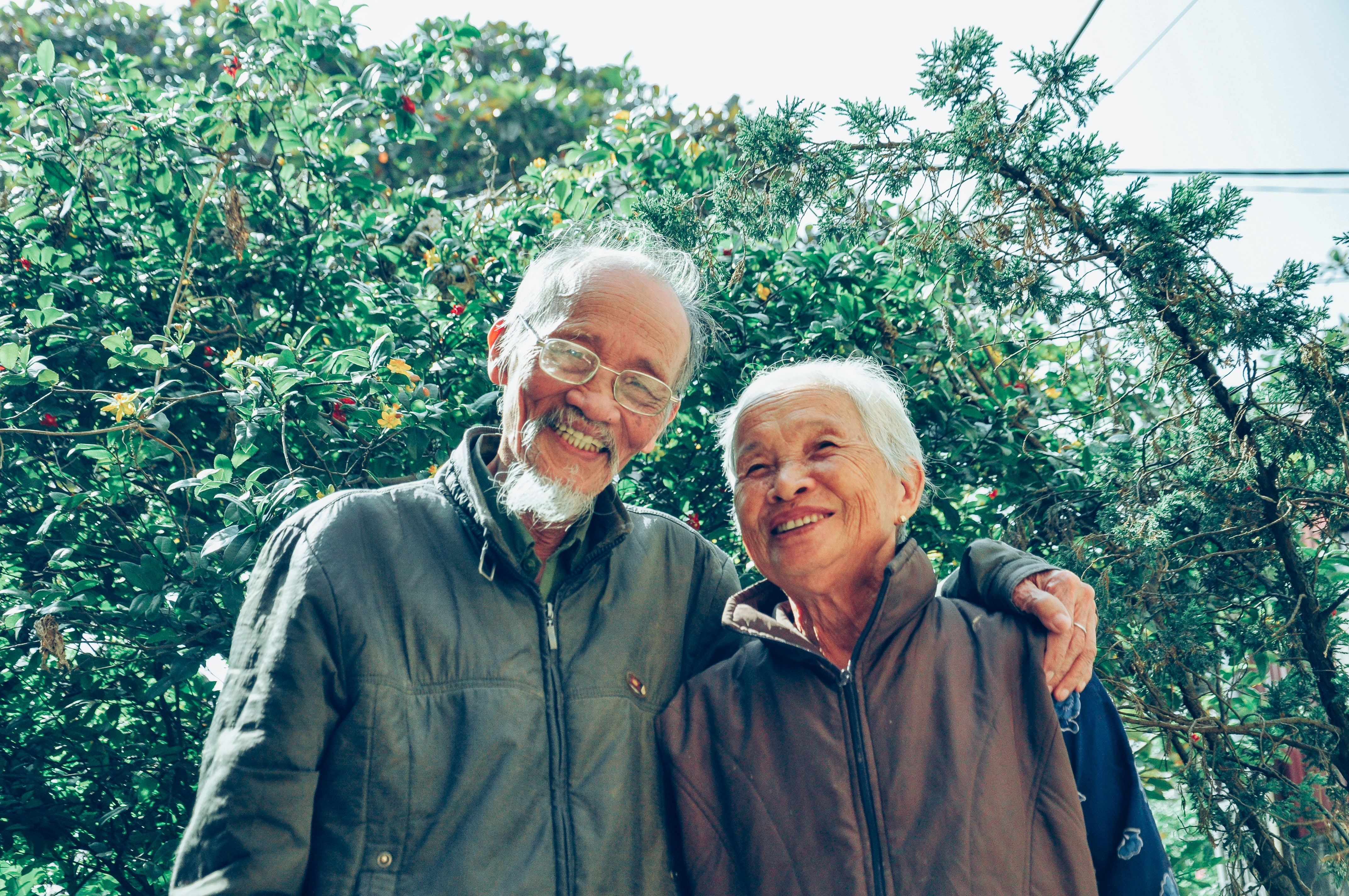 elderly couple smiling among trees