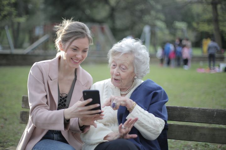 senior and daughter looking at phone