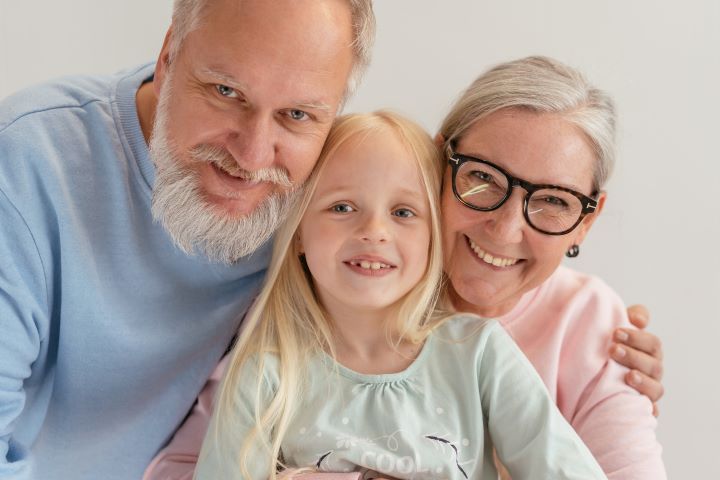 smiling grandparents and granddaughter