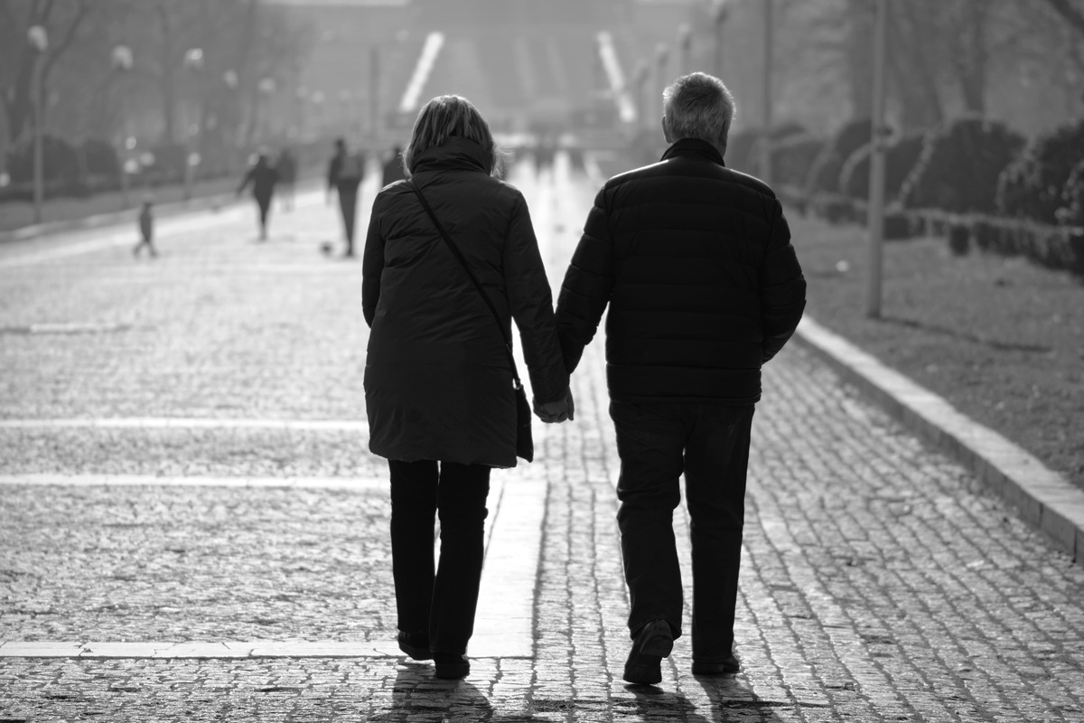 man and woman holding hands walking in winter coats