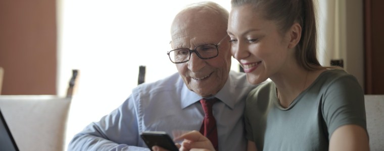 elderly man using phone and laptop for tax services
