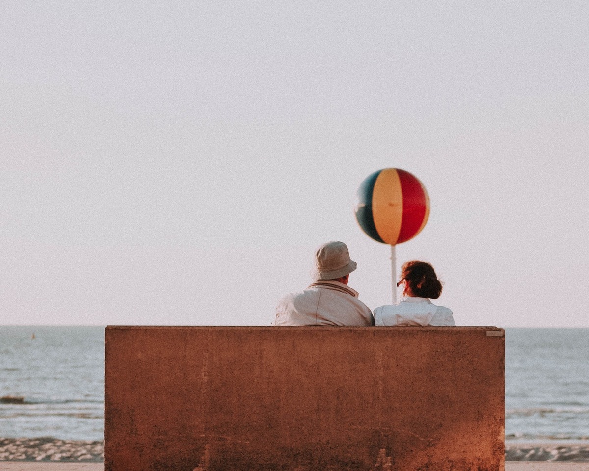 elderly couple sitting seaside
