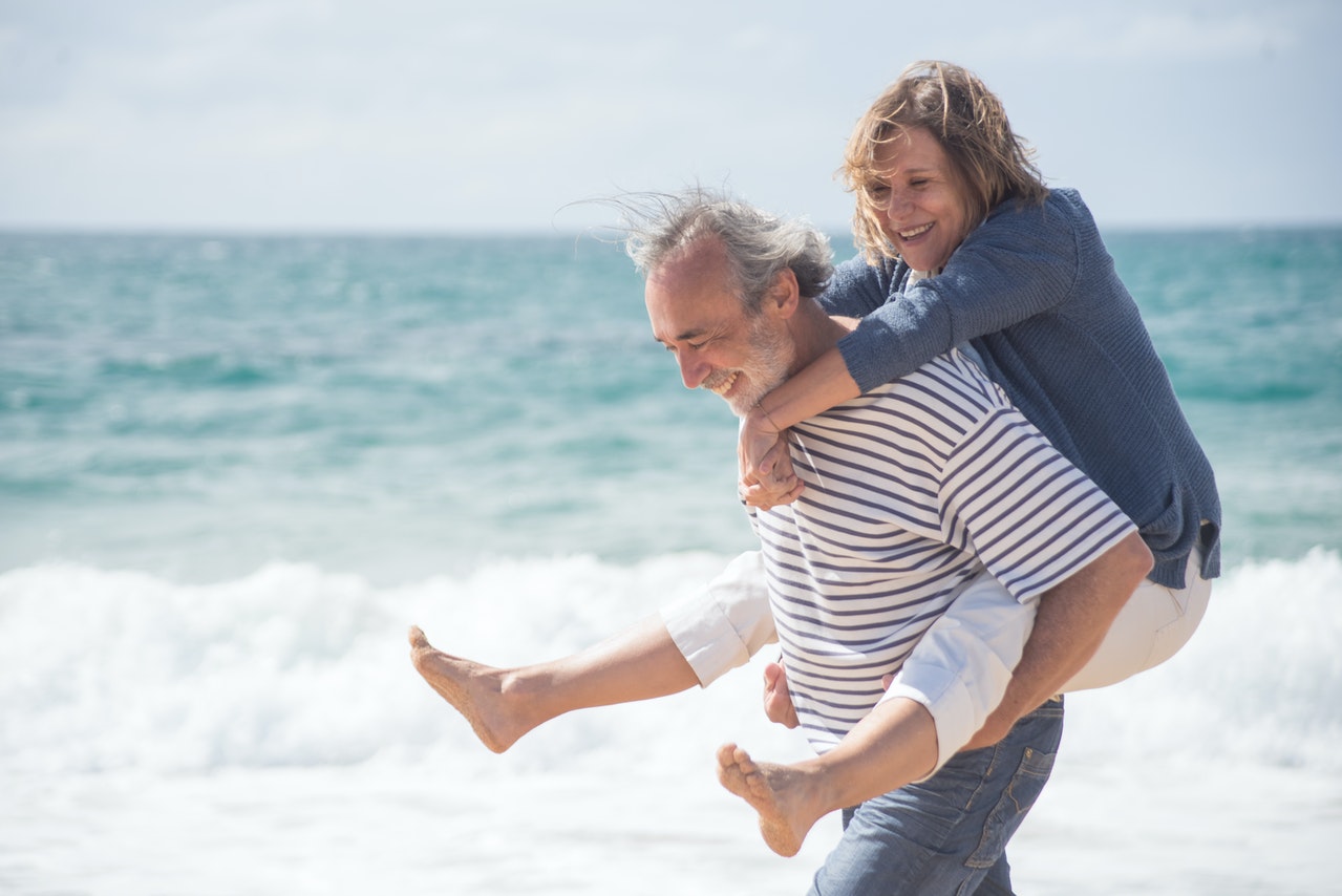 woman on husband's back on the beach
