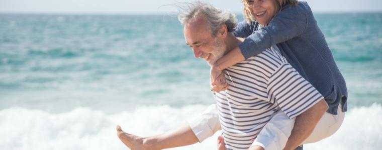 woman on husband's back on the beach