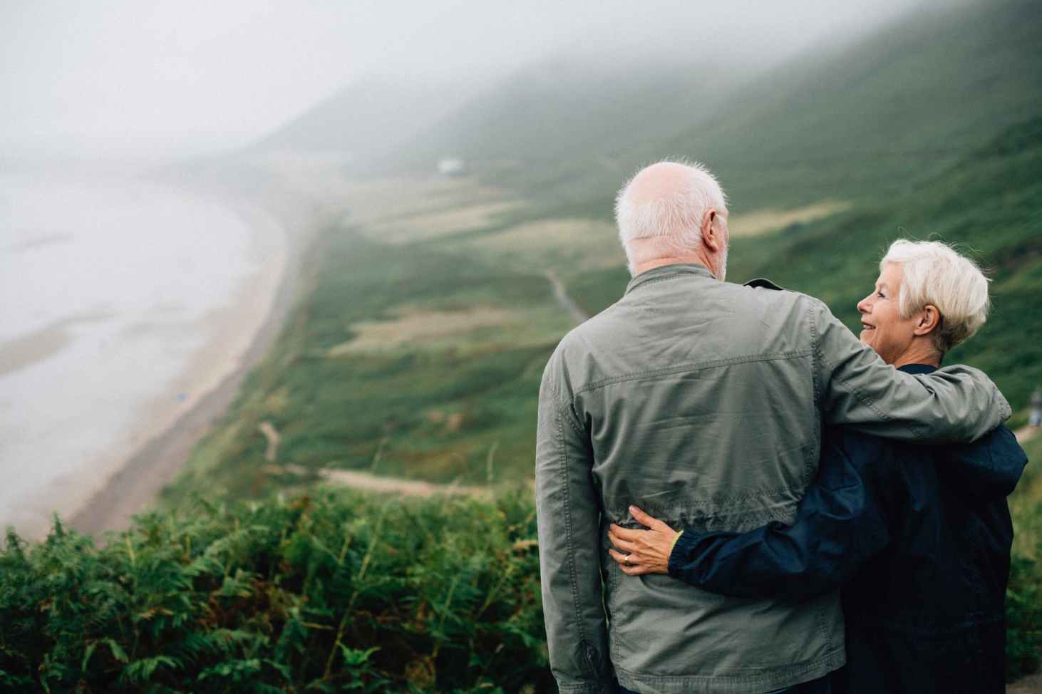 husband and wife at top of mountain looking at each other