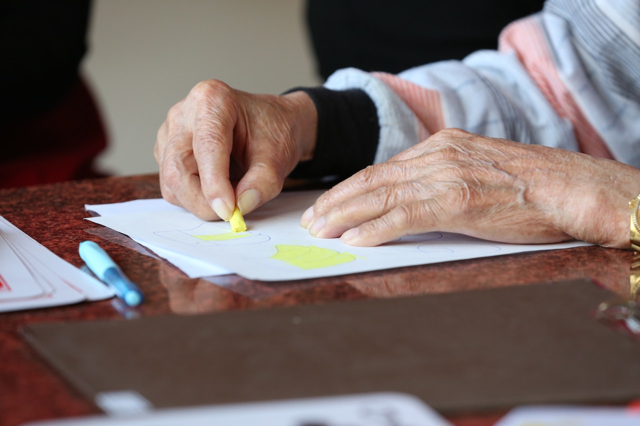 elderly hands drawing during therapy at nursing home