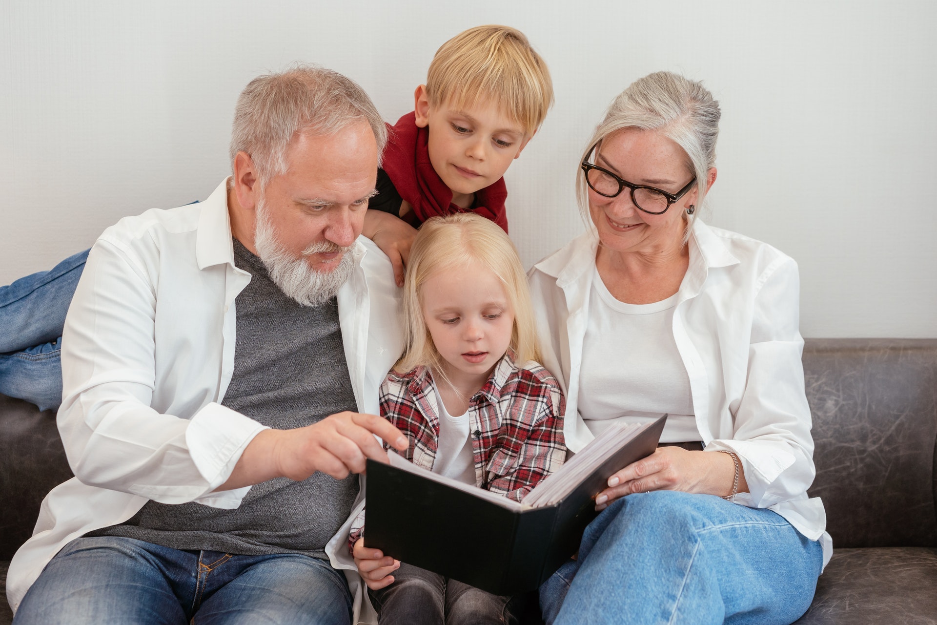 grandparents reading a book with their grandchildren
